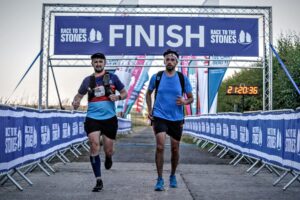 two charity participants crossing the finish line