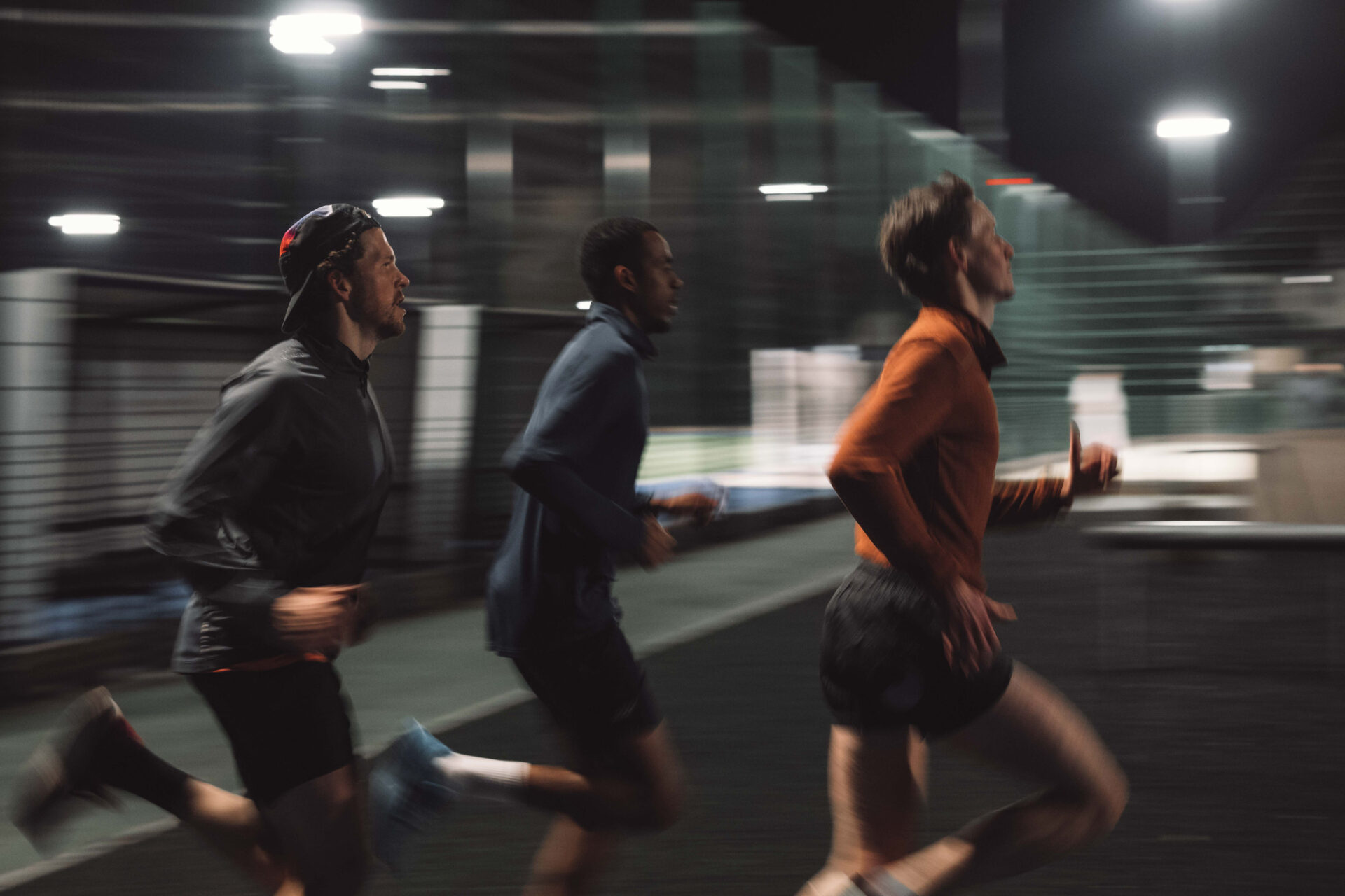 3 men running on local track 